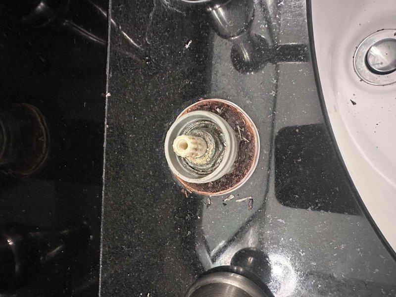 Responded to service call for leaking bathroom faucet with three-handle configuration (hot/cold handles and center spout) in brushed nickel finish mounted on black granite countertop. Upon inspection, identified deteriorated seals and gaskets at base of fixture causing water seepage, evidenced by mineral deposits and buildup around mounting plates. Provided comprehensive assessment and repair estimate for seal replacement and proper reseating of faucet components to eliminate leak. Responded to service call for leaking bathroom faucet with three-handle configuration (hot/cold handles and center spout) in brushed nickel finish mounted on black granite countertop. Upon inspection, identified deteriorated seals and gaskets at base of fixture causing water seepage, evidenced by mineral deposits and buildup around mounting plates. Provided comprehensive assessment and repair estimate for seal replacement and proper reseating of faucet components to eliminate leak.