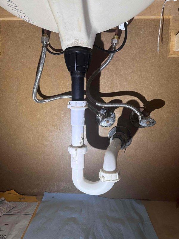 Completed faucet replacement in bathroom sink with widespread three-piece brushed nickel fixture featuring two separate handles and central spout. Installed new drain assembly with P-trap configuration and connected braided metal supply lines to ensure proper water flow and drainage functionality. Completed faucet replacement in bathroom sink with widespread three-piece brushed nickel fixture featuring two separate handles and central spout. Installed new drain assembly with P-trap configuration and connected braided metal supply lines to ensure proper water flow and drainage functionality.