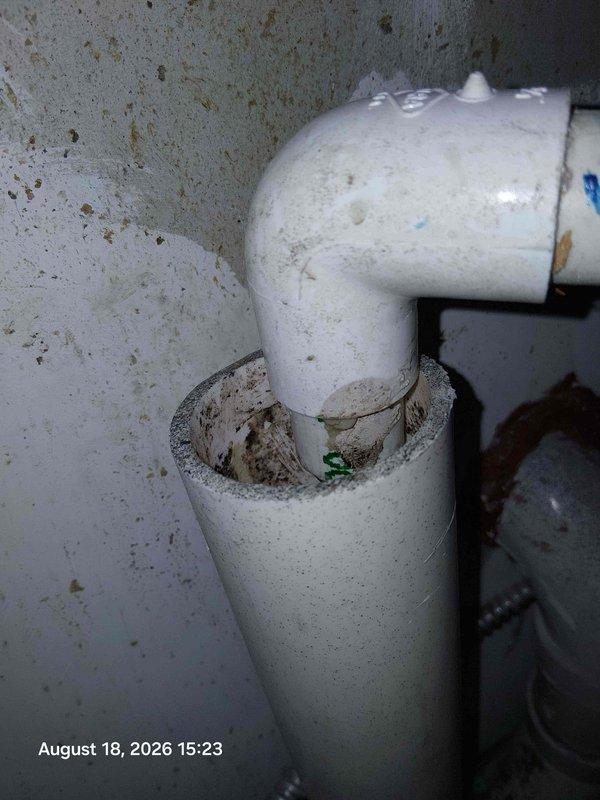 Responded to active leak in bathroom where deteriorated PVC pipe joint was allowing water intrusion. Upon inspection, identified failed elbow connection with visible cracks and material deterioration at the joint. Documented existing conditions showing aging infrastructure with accumulated debris and compromised pipe integrity requiring immediate attention to prevent further water damage. Responded to active leak in bathroom where deteriorated PVC pipe joint was allowing water intrusion. Upon inspection, identified failed elbow connection with visible cracks and material deterioration at the joint. Documented existing conditions showing aging infrastructure with accumulated debris and compromised pipe integrity requiring immediate attention to prevent further water damage.