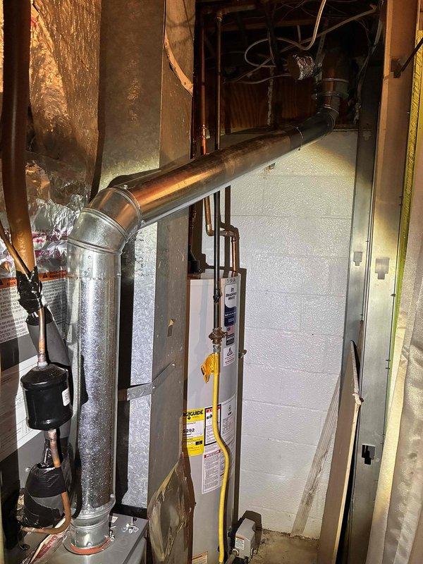 # HVAC Vent Pipe Assessment
Conducted on-site evaluation of existing HVAC exhaust venting system in residential basement mechanical room. Inspected current single-wall metal ductwork configuration connected to furnace unit. Assessed installation routing, clearances from combustible materials, and compliance requirements for proper venting. Documented existing conditions including galvanized metal duct with elbow joint, connection points at air handler unit, and proximity to building structure and insulation materials. Evaluated space constraints and accessibility for potential conversion to double-wall vent pipe system. Photographed current installation showing ductwork path, equipment layout, copper piping, water heater location, and mechanical room configuration to support estimate preparation for upgrading to code-compliant double-wall venting. # HVAC Vent Pipe Assessment
Conducted on-site evaluation of existing HVAC exhaust venting system in residential basement mechanical room. Inspected current single-wall metal ductwork configuration connected to furnace unit. Assessed installation routing, clearances from combustible materials, and compliance requirements for proper venting. Documented existing conditions including galvanized metal duct with elbow joint, connection points at air handler unit, and proximity to building structure and insulation materials. Evaluated space constraints and accessibility for potential conversion to double-wall vent pipe system. Photographed current installation showing ductwork path, equipment layout, copper piping, water heater location, and mechanical room configuration to support estimate preparation for upgrading to code-compliant double-wall venting.