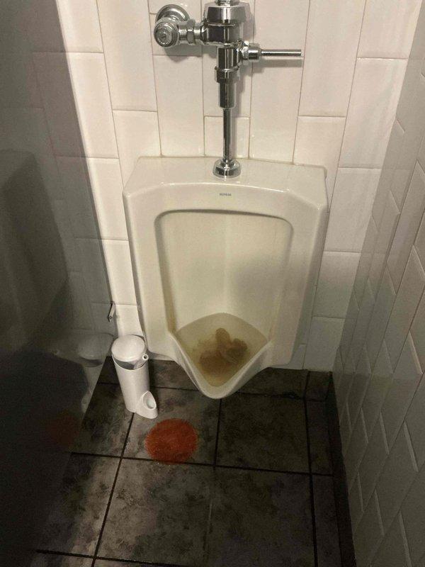 Responded to commercial restroom for reported urinal clog. Upon arrival, inspected wall-mounted Kohler urinal and identified drainage obstruction preventing proper water flow. Cleared blockage using appropriate drain cleaning equipment and restored full drainage function. Tested flush valve operation and verified complete water evacuation through drain system. Noted mineral deposits and staining around drain connection point indicating long-term moisture issues. Advised facility maintenance of condition and recommended regular preventative maintenance to minimize future clogs. Responded to commercial restroom for reported urinal clog. Upon arrival, inspected wall-mounted Kohler urinal and identified drainage obstruction preventing proper water flow. Cleared blockage using appropriate drain cleaning equipment and restored full drainage function. Tested flush valve operation and verified complete water evacuation through drain system. Noted mineral deposits and staining around drain connection point indicating long-term moisture issues. Advised facility maintenance of condition and recommended regular preventative maintenance to minimize future clogs.
