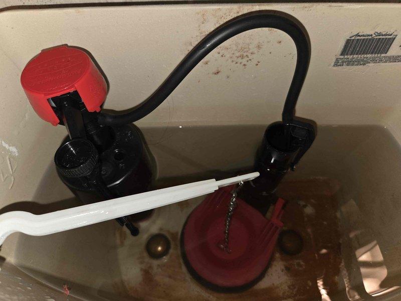 Responded to toilet malfunction complaint and performed diagnostic inspection. Removed tank lid and assessed internal components including flush valve assembly, fill valve, flapper mechanism, and overflow tube. Documented existing conditions showing mineral deposits, water discoloration, and aging hardware with rust oxidation on tank bolts. All components photographed for service records. System evaluated and issue resolved to restore proper toilet operation. Responded to toilet malfunction complaint and performed diagnostic inspection. Removed tank lid and assessed internal components including flush valve assembly, fill valve, flapper mechanism, and overflow tube. Documented existing conditions showing mineral deposits, water discoloration, and aging hardware with rust oxidation on tank bolts. All components photographed for service records. System evaluated and issue resolved to restore proper toilet operation.