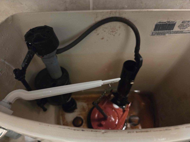 Responded to toilet malfunction complaint and performed diagnostic inspection. Removed tank lid and assessed internal components including flush valve assembly, fill valve, flapper mechanism, and overflow tube. Documented existing conditions showing mineral deposits, water discoloration, and aging hardware with rust oxidation on tank bolts. All components photographed for service records. System evaluated and issue resolved to restore proper toilet operation. Responded to toilet malfunction complaint and performed diagnostic inspection. Removed tank lid and assessed internal components including flush valve assembly, fill valve, flapper mechanism, and overflow tube. Documented existing conditions showing mineral deposits, water discoloration, and aging hardware with rust oxidation on tank bolts. All components photographed for service records. System evaluated and issue resolved to restore proper toilet operation.