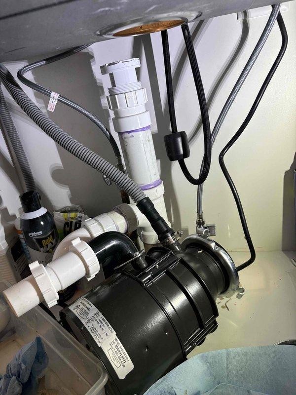 Responded to service call for leak detection and repair at kitchen sink plumbing system. Upon inspection, located leak source in under-sink plumbing assembly involving garbage disposal unit and associated drainage piping. Examined PVC P-trap configuration, disposal mounting assembly, and dishwasher drain line connections. Identified compromised connection points and addressed leak at disposal unit interface. Tightened mounting hardware, verified proper seal at sink flange connection, and inspected all PVC joints and hose clamp connections for integrity. Tested system operation and confirmed leak was successfully repaired with no further water discharge detected. Responded to service call for leak detection and repair at kitchen sink plumbing system. Upon inspection, located leak source in under-sink plumbing assembly involving garbage disposal unit and associated drainage piping. Examined PVC P-trap configuration, disposal mounting assembly, and dishwasher drain line connections. Identified compromised connection points and addressed leak at disposal unit interface. Tightened mounting hardware, verified proper seal at sink flange connection, and inspected all PVC joints and hose clamp connections for integrity. Tested system operation and confirmed leak was successfully repaired with no further water discharge detected.