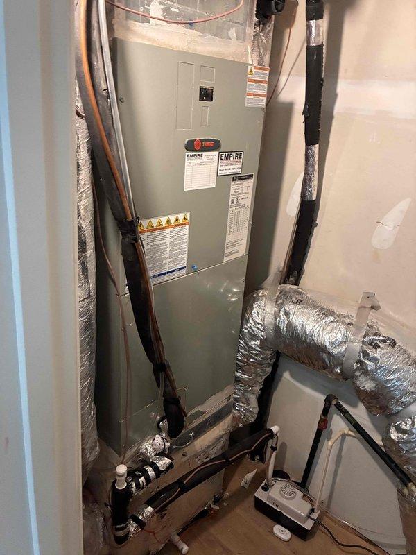 Inspected condensate pump and associated HVAC system in attic installation. Documented Empire air handler unit with refrigerant lines, flexible ductwork, PVC condensate drain lines, and wall-mounted condensate pump to verify proper operation and identify any drainage concerns. Inspected condensate pump and associated HVAC system in attic installation. Documented Empire air handler unit with refrigerant lines, flexible ductwork, PVC condensate drain lines, and wall-mounted condensate pump to verify proper operation and identify any drainage concerns.