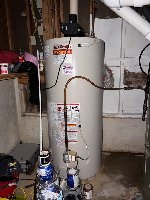 Responded to service call for leaking 80-gallon gas water heater. Upon arrival, performed inspection of existing unit and confirmed active leak requiring immediate replacement due to customer's travel schedule. Successfully removed failed water heater and installed new A.O. Smith ProMax gas water heater. Connected copper supply lines to top of unit, installed shutoff valve with blue handle on cold water supply line, and secured all piping with appropriate mounting brackets to wall. Completed all gas line connections, tested system for proper operation and leaks, and verified temperature and pressure relief valve functionality. Installation completed prior to customer's departure time, ensuring no water damage would occur during their absence. Responded to service call for leaking 80-gallon gas water heater. Upon arrival, performed inspection of existing unit and confirmed active leak requiring immediate replacement due to customer's travel schedule. Successfully removed failed water heater and installed new A.O. Smith ProMax gas water heater. Connected copper supply lines to top of unit, installed shutoff valve with blue handle on cold water supply line, and secured all piping with appropriate mounting brackets to wall. Completed all gas line connections, tested system for proper operation and leaks, and verified temperature and pressure relief valve functionality. Installation completed prior to customer's departure time, ensuring no water damage would occur during their absence.