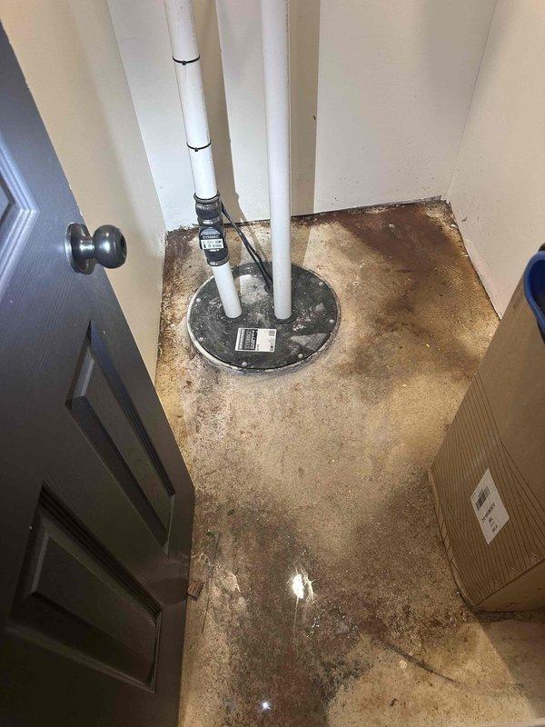 Responded to customer report of water leak in basement beneath main bathroom area. Conducted thorough inspection of confined utility space, examining plumbing connections, drainage systems, and HVAC ductwork in vicinity of reported leak. Utilized flashlight to inspect wall-to-floor junctions, PVC drainage piping, and mechanical components for signs of active water intrusion or moisture damage. Observed cracking in wall surfaces and previous water staining on concrete floor.
Inspected sump pump system as requested, examining dual vertical discharge pipes, mounting straps, electronic sensor components, and pump basin cover. Noted extensive historical water staining and discoloration on concrete floor surrounding sump pump installation, indicating past moisture events. Evaluated overall condition of sump pump assembly and drainage configuration. Documented findings with photographic evidence of inspection areas for customer records. Responded to customer report of water leak in basement beneath main bathroom area. Conducted thorough inspection of confined utility space, examining plumbing connections, drainage systems, and HVAC ductwork in vicinity of reported leak. Utilized flashlight to inspect wall-to-floor junctions, PVC drainage piping, and mechanical components for signs of active water intrusion or moisture damage. Observed cracking in wall surfaces and previous water staining on concrete floor.
Inspected sump pump system as requested, examining dual vertical discharge pipes, mounting straps, electronic sensor components, and pump basin cover. Noted extensive historical water staining and discoloration on concrete floor surrounding sump pump installation, indicating past moisture events. Evaluated overall condition of sump pump assembly and drainage configuration. Documented findings with photographic evidence of inspection areas for customer records.