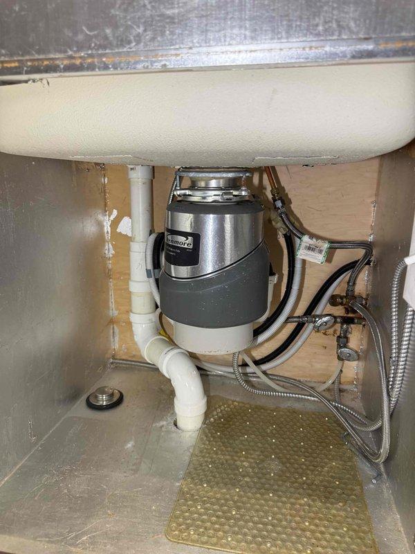 Completed replacement of two garbage disposal units in kitchen sink cabinets. Removed existing disposals and installed new InSinkErator 1.0 HP garbage disposal units beneath sink basins, connecting to existing white PVC drain lines and verifying proper electrical connections. All plumbing connections secured and tested for leaks, with braided supply lines and shut-off valves confirmed operational. Completed replacement of two garbage disposal units in kitchen sink cabinets. Removed existing disposals and installed new InSinkErator 1.0 HP garbage disposal units beneath sink basins, connecting to existing white PVC drain lines and verifying proper electrical connections. All plumbing connections secured and tested for leaks, with braided supply lines and shut-off valves confirmed operational.