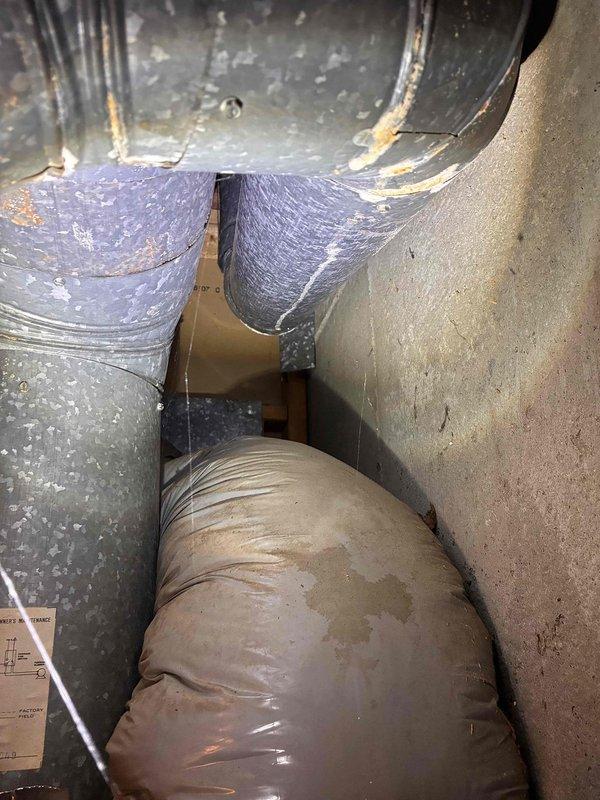 Responded to service call for AC unit inspection following tree damage. Upon arrival, conducted thorough visual assessment of outdoor condensing unit and accessible ductwork components. Examined exterior unit housing, fan assembly, and surrounding installation area for impact damage, structural compromise, or debris intrusion. Inspected indoor ductwork sections including flexible ducting and rigid purple-wrapped insulated runs for displacement, crushing, or separation at connection points. Documented current condition of all accessible HVAC components through comprehensive photography for insurance and repair assessment purposes. Unit remains in place on concrete pad with no immediate visible catastrophic damage to major components, though further diagnostic testing recommended before operation. Responded to service call for AC unit inspection following tree damage. Upon arrival, conducted thorough visual assessment of outdoor condensing unit and accessible ductwork components. Examined exterior unit housing, fan assembly, and surrounding installation area for impact damage, structural compromise, or debris intrusion. Inspected indoor ductwork sections including flexible ducting and rigid purple-wrapped insulated runs for displacement, crushing, or separation at connection points. Documented current condition of all accessible HVAC components through comprehensive photography for insurance and repair assessment purposes. Unit remains in place on concrete pad with no immediate visible catastrophic damage to major components, though further diagnostic testing recommended before operation.