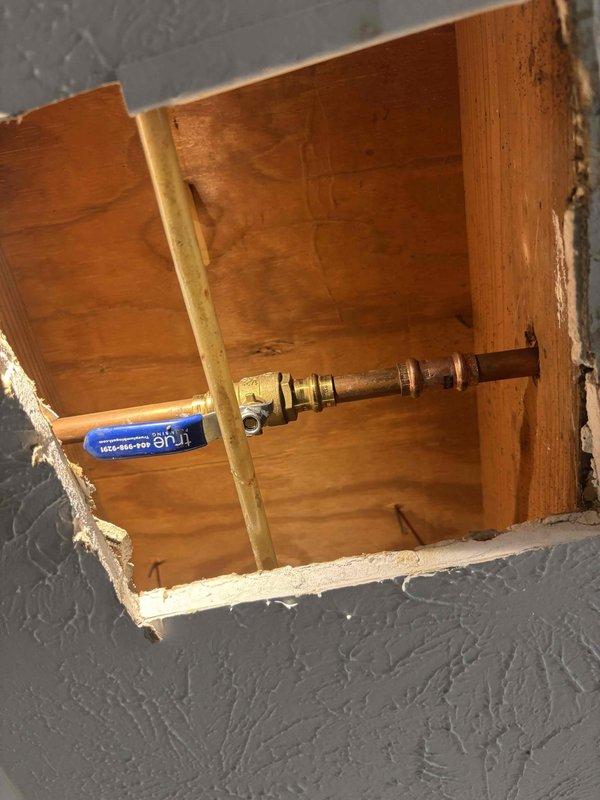Responded to leaking valve serving outdoor hose bibb in Unit H-1. Created wall access opening to expose faulty valve assembly on copper water supply line. Replaced defective valve with new brass shut-off valve featuring quarter-turn ball valve mechanism with blue handle for positive shut-off control. Tested system under pressure to verify complete seal and proper operation. Access opening left for HOA-approved completion of drywall repair and finish work. Responded to leaking valve serving outdoor hose bibb in Unit H-1. Created wall access opening to expose faulty valve assembly on copper water supply line. Replaced defective valve with new brass shut-off valve featuring quarter-turn ball valve mechanism with blue handle for positive shut-off control. Tested system under pressure to verify complete seal and proper operation. Access opening left for HOA-approved completion of drywall repair and finish work.