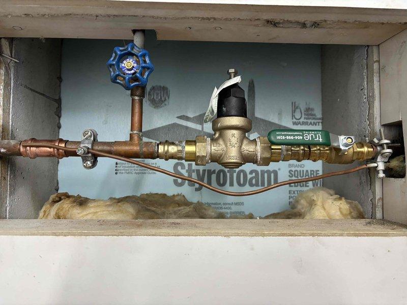 Responded to customer report of garbage disposal leak causing water damage to basement ceiling. Upon inspection, discovered significant water damage to cabinet flooring beneath kitchen sink, with extensive cracking, staining, and deterioration of substrate material indicating prolonged moisture exposure. Assessed plumbing connections including water heater supply lines, pressure reducing valve, and main water supply piping with shut-off valve. Documented condition of all visible plumbing components and water-damaged areas for repair recommendations. Responded to customer report of garbage disposal leak causing water damage to basement ceiling. Upon inspection, discovered significant water damage to cabinet flooring beneath kitchen sink, with extensive cracking, staining, and deterioration of substrate material indicating prolonged moisture exposure. Assessed plumbing connections including water heater supply lines, pressure reducing valve, and main water supply piping with shut-off valve. Documented condition of all visible plumbing components and water-damaged areas for repair recommendations.