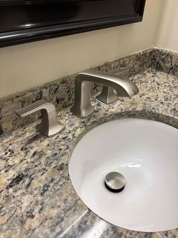 Responded to Room 314 for a clogged toilet and installation of customer-supplied faucet. Successfully cleared the toilet obstruction and restored proper drainage. Installed a three-piece widespread faucet assembly with brushed nickel finish on the granite vanity countertop, including central arched spout and two matching lever handles. Connected supply lines to existing shut-off valves beneath the sink. Tested all components for proper operation and verified no leaks at connections. Installation completed with fixtures functioning correctly. Responded to Room 314 for a clogged toilet and installation of customer-supplied faucet. Successfully cleared the toilet obstruction and restored proper drainage. Installed a three-piece widespread faucet assembly with brushed nickel finish on the granite vanity countertop, including central arched spout and two matching lever handles. Connected supply lines to existing shut-off valves beneath the sink. Tested all components for proper operation and verified no leaks at connections. Installation completed with fixtures functioning correctly.