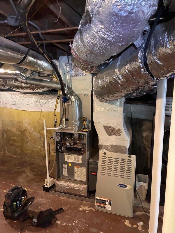 Completed comprehensive fall maintenance on residential Carrier furnace system located in basement mechanical room. Performed thorough inspection of heating unit, verified proper operation of all safety controls, checked and cleaned burner assembly, and inspected heat exchanger for cracks or deterioration. Evaluated furnace ventilation louvers and confirmed adequate airflow throughout the system.
Inspected extensive flexible ductwork system throughout basement and crawl space areas, checking for proper support, secure connections, and signs of air leakage. Examined metallic duct tape seals and insulation integrity on all accessible runs. Assessed gray flexible ductwork in crawl space area running through confined space with exposed brick walls and wooden joists, confirming proper installation and structural support.
Verified vapor barrier and insulation materials in crawl space mechanical area remain properly positioned to prevent moisture infiltration and maintain system efficiency. Completed comprehensive fall maintenance on residential Carrier furnace system located in basement mechanical room. Performed thorough inspection of heating unit, verified proper operation of all safety controls, checked and cleaned burner assembly, and inspected heat exchanger for cracks or deterioration. Evaluated furnace ventilation louvers and confirmed adequate airflow throughout the system.
Inspected extensive flexible ductwork system throughout basement and crawl space areas, checking for proper support, secure connections, and signs of air leakage. Examined metallic duct tape seals and insulation integrity on all accessible runs. Assessed gray flexible ductwork in crawl space area running through confined space with exposed brick walls and wooden joists, confirming proper installation and structural support.
Verified vapor barrier and insulation materials in crawl space mechanical area remain properly positioned to prevent moisture infiltration and maintain system efficiency.