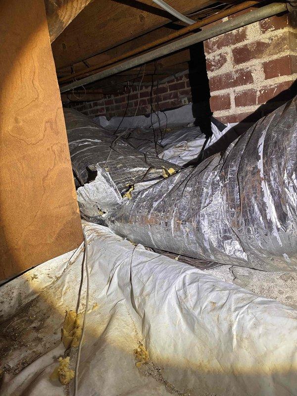 Completed comprehensive fall maintenance on residential Carrier furnace system located in basement mechanical room. Performed thorough inspection of heating unit, verified proper operation of all safety controls, checked and cleaned burner assembly, and inspected heat exchanger for cracks or deterioration. Evaluated furnace ventilation louvers and confirmed adequate airflow throughout the system.
Inspected extensive flexible ductwork system throughout basement and crawl space areas, checking for proper support, secure connections, and signs of air leakage. Examined metallic duct tape seals and insulation integrity on all accessible runs. Assessed gray flexible ductwork in crawl space area running through confined space with exposed brick walls and wooden joists, confirming proper installation and structural support.
Verified vapor barrier and insulation materials in crawl space mechanical area remain properly positioned to prevent moisture infiltration and maintain system efficiency. Completed comprehensive fall maintenance on residential Carrier furnace system located in basement mechanical room. Performed thorough inspection of heating unit, verified proper operation of all safety controls, checked and cleaned burner assembly, and inspected heat exchanger for cracks or deterioration. Evaluated furnace ventilation louvers and confirmed adequate airflow throughout the system.
Inspected extensive flexible ductwork system throughout basement and crawl space areas, checking for proper support, secure connections, and signs of air leakage. Examined metallic duct tape seals and insulation integrity on all accessible runs. Assessed gray flexible ductwork in crawl space area running through confined space with exposed brick walls and wooden joists, confirming proper installation and structural support.
Verified vapor barrier and insulation materials in crawl space mechanical area remain properly positioned to prevent moisture infiltration and maintain system efficiency.