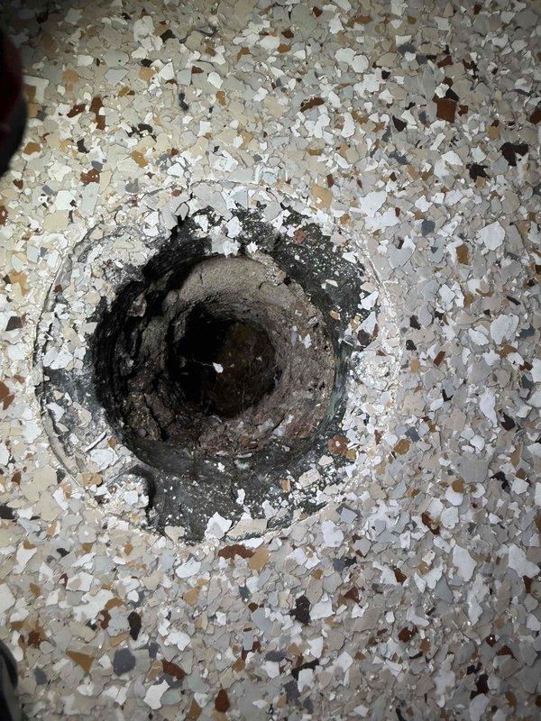 Responded to a clogged floor drain in the garage that was backing up. Upon inspection, found the drain opening showed significant age and debris accumulation around the rim with visible deterioration of the surrounding terrazzo flooring. Successfully cleared the obstruction and restored proper drainage function to the floor drain system. Responded to a clogged floor drain in the garage that was backing up. Upon inspection, found the drain opening showed significant age and debris accumulation around the rim with visible deterioration of the surrounding terrazzo flooring. Successfully cleared the obstruction and restored proper drainage function to the floor drain system.