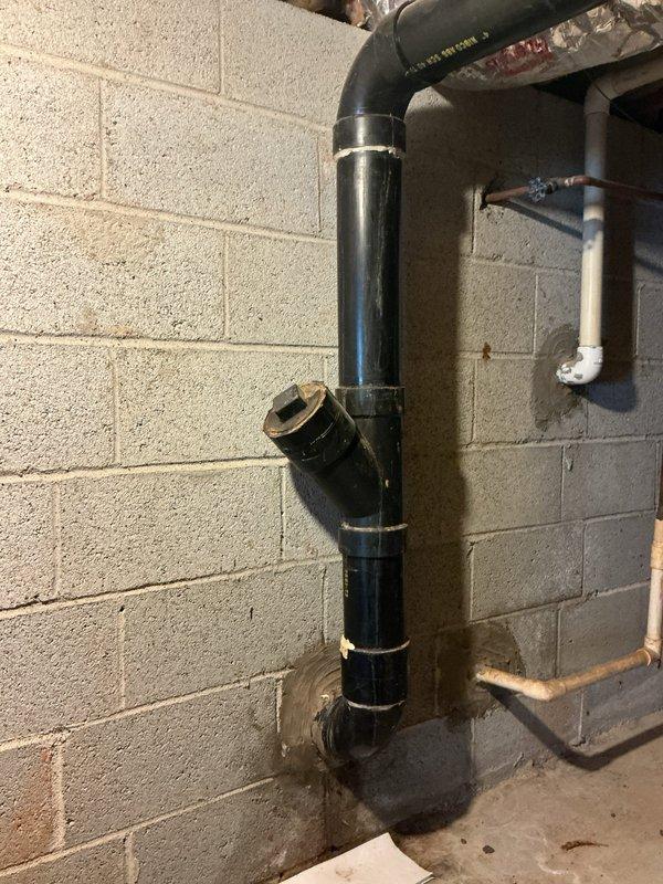 Responded to basement drain stack leak complaint. Upon inspection, identified leak at black ABS/PVC drain stack assembly mounted to concrete block wall. Repaired compromised section of vertical drainage piping including 90-degree elbow joint and T-junction connection. Secured all pipe sections with proper metal clamps and straps to ensure stability. Verified system integrity and confirmed leak resolution. Responded to basement drain stack leak complaint. Upon inspection, identified leak at black ABS/PVC drain stack assembly mounted to concrete block wall. Repaired compromised section of vertical drainage piping including 90-degree elbow joint and T-junction connection. Secured all pipe sections with proper metal clamps and straps to ensure stability. Verified system integrity and confirmed leak resolution.