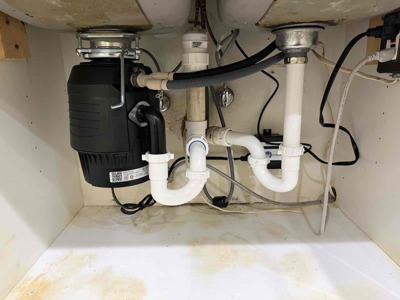 Completed multiple plumbing tasks per the approved scope, including installation of the customer-supplied kitchen faucet. Worked within the under-sink cabinet to service the double-basin P-trap drain assembly, garbage disposal connection, and chrome angle stop valves with braided supply lines, verifying secure slip-joint connections and proper operation. Noted staining and discoloration on the PVC drain piping and cabinet floor consistent with prior moisture exposure, and confirmed no active leaks at completion. Completed multiple plumbing tasks per the approved scope, including installation of the customer-supplied kitchen faucet. Worked within the under-sink cabinet to service the double-basin P-trap drain assembly, garbage disposal connection, and chrome angle stop valves with braided supply lines, verifying secure slip-joint connections and proper operation. Noted staining and discoloration on the PVC drain piping and cabinet floor consistent with prior moisture exposure, and confirmed no active leaks at completion.
