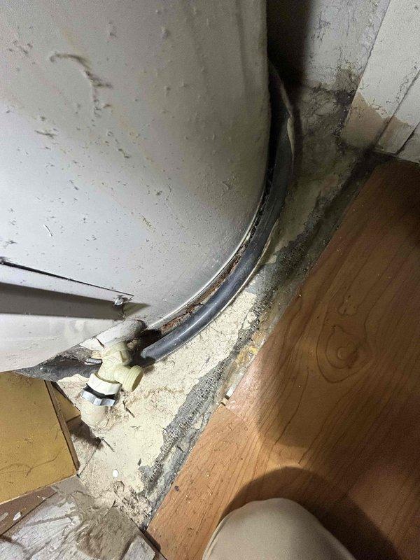 Responded to a reported water leak originating from an upper unit and migrating to the unit below, and inspected the water heater and laundry closet. The water heater showed heavy corrosion staining at the base, deteriorated sealant on the floor, and a clamped supply fitting near the bottom, indicating prior moisture exposure, while the laundry closet's washing machine supply hoses, valves, and dryer vent showed no visible leaks or damage. Findings were documented with photos for further evaluation and repair. Responded to a reported water leak originating from an upper unit and migrating to the unit below, and inspected the water heater and laundry closet. The water heater showed heavy corrosion staining at the base, deteriorated sealant on the floor, and a clamped supply fitting near the bottom, indicating prior moisture exposure, while the laundry closet's washing machine supply hoses, valves, and dryer vent showed no visible leaks or damage. Findings were documented with photos for further evaluation and repair.