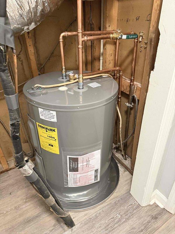 Installed a new electric water heater in the utility closet, set within a metal drain pan, with new copper supply piping, brass fittings, a shutoff valve, and a flexible connector to the tank. Water supply and electrical connections were completed, and the installation was left free of visible leaks, rust, or damage, with the manufacturer warranty documentation attached to the unit. Installed a new electric water heater in the utility closet, set within a metal drain pan, with new copper supply piping, brass fittings, a shutoff valve, and a flexible connector to the tank. Water supply and electrical connections were completed, and the installation was left free of visible leaks, rust, or damage, with the manufacturer warranty documentation attached to the unit.