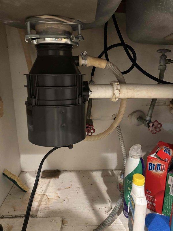 Inspected the kitchen sink garbage disposal reported as clogged with suspected glass debris. Accessed the unit and drain assembly beneath the sink, cleared the obstruction from the disposal chamber, and verified the connections to the corrugated drain hose and PVC drain line were secure. Tested the disposal and drain for proper operation and flow. Inspected the kitchen sink garbage disposal reported as clogged with suspected glass debris. Accessed the unit and drain assembly beneath the sink, cleared the obstruction from the disposal chamber, and verified the connections to the corrugated drain hose and PVC drain line were secure. Tested the disposal and drain for proper operation and flow.