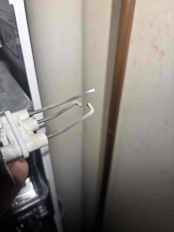 Diagnosed a Navien tankless water heater that was intermittently shutting down with a blinking red indicator during extended demand, and the controller logged Error 003 (Ignition Failure). Inspection of the ignition electrode assembly revealed oxidized, chalky buildup on the electrodes and bent, misaligned tips, which prevented reliable ignition and flame sensing. The ignition assembly was removed and found to be deteriorated, and the unit was serviced to restore proper ignition and sustained operation. Diagnosed a Navien tankless water heater that was intermittently shutting down with a blinking red indicator during extended demand, and the controller logged Error 003 (Ignition Failure). Inspection of the ignition electrode assembly revealed oxidized, chalky buildup on the electrodes and bent, misaligned tips, which prevented reliable ignition and flame sensing. The ignition assembly was removed and found to be deteriorated, and the unit was serviced to restore proper ignition and sustained operation.