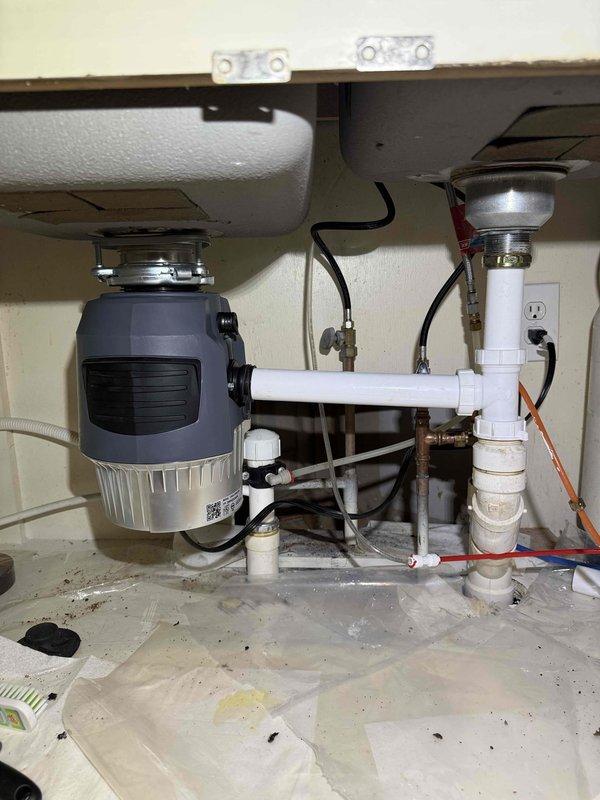 Installed customer-supplied brushed-nickel pull-down kitchen faucet on the double-basin sink and verified proper flow and drainage with no leaks. Mounted and connected the customer-supplied garbage disposal beneath the left basin, tying its discharge into the existing PVC drain assembly and confirming secure connections and normal operation. Installed customer-supplied brushed-nickel pull-down kitchen faucet on the double-basin sink and verified proper flow and drainage with no leaks. Mounted and connected the customer-supplied garbage disposal beneath the left basin, tying its discharge into the existing PVC drain assembly and confirming secure connections and normal operation.