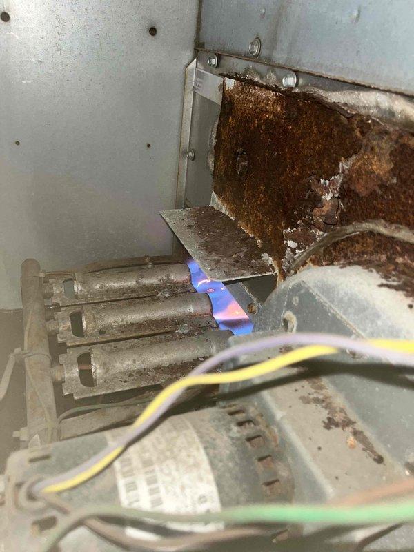 Performed diagnostic on commercial heating system reporting no heat. Identified significant rust and corrosion on heat exchanger. Unit was operational with blue flame visible on burners during inspection. Documented equipment information from data plate (model SRAJ90SA115EA04AA) and visually inspected components for proper functionality.