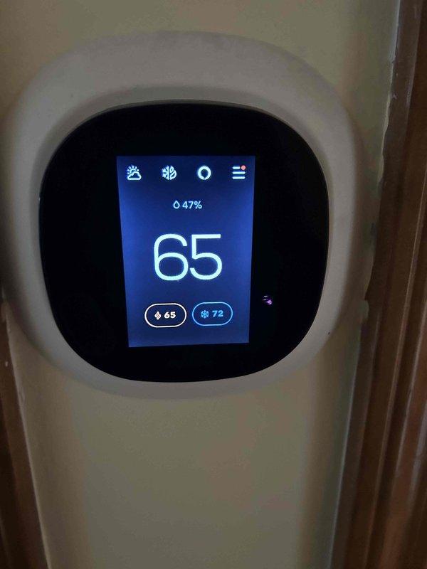 Conducted inspection of customer's existing 2004 furnace system to provide replacement quote as requested. System is currently operational but at end of recommended service life. Documented current setup including digital programmable thermostat showing 65°F setting and electrical panel configuration for proper sizing of replacement unit.