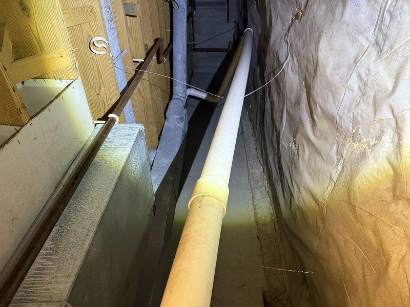 Inspected ductwork in crawl space to evaluate airflow issues. Documented existing PVC piping configuration and examined adjacent HVAC components with exposed framing. Identified areas where modifications would be needed to improve air circulation throughout the system.