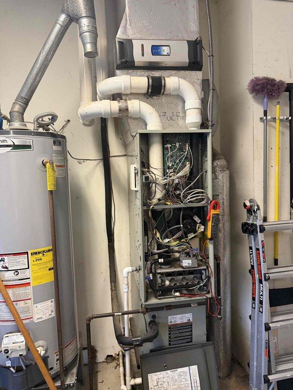 Responded to second opinion request for 15-year-old non-functioning furnace under home warranty coverage. Upon inspection, identified the unit with exposed internal wiring and circuit board components. System appears to be part of an integrated setup with water treatment equipment and visible PVC ventilation pipes. Customer advised that replacement may be necessary due to age and complete heat loss since 11/25.