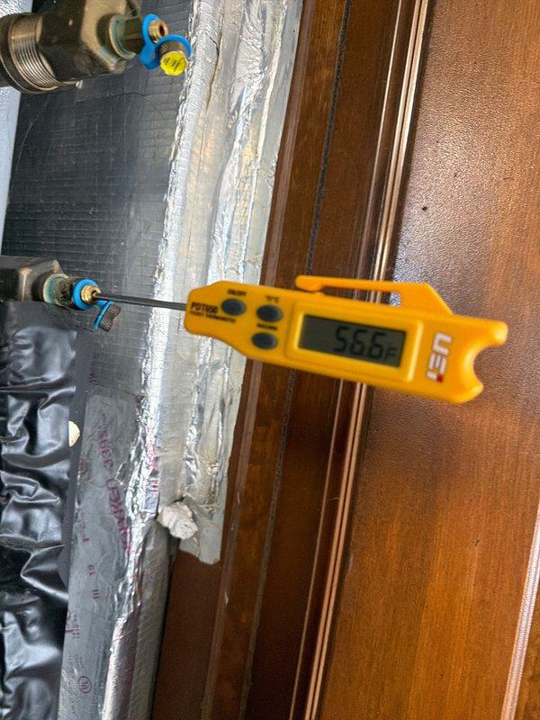 Completed annual heating maintenance on geothermal system. Measured loop temperature at 55.6°F using UEi thermometer at valve connection points, confirming proper operating range. Electrical diagnostics with Fluke 902FC clamp meter showed compressor drawing 0.1 amps at idle, indicating normal electrical function. System is operating within manufacturer specifications for the heating season.