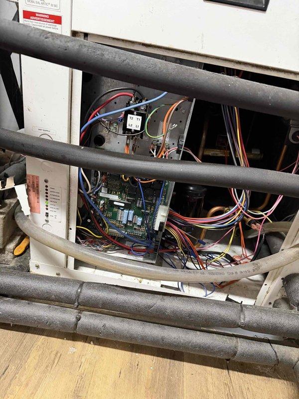 Performed annual heating maintenance on geothermal system. Inspected control board and wiring connections, confirming proper installation with no visible damage. Voltage testing showed readings within normal operating parameters (21.83V), indicating system is functioning correctly.