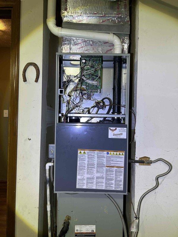 Conducted comprehensive evaluation of existing Bassett furnace system for potential replacement per customer request, following referral from previous clients. Inspected current installation including wall-mounted unit, ductwork with reflective foil insulation, and PVC venting connections. Verified functionality of Honeywell digital thermostat (currently set at 70°F) and assessed overall system compatibility for recommended replacement options.