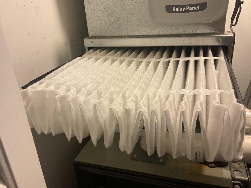 Inspected furnace system after reported thermostat malfunction. Found severely clogged air filter, replaced with new pleated filter and verified proper installation in relay panel housing. System now operating correctly with improved airflow.