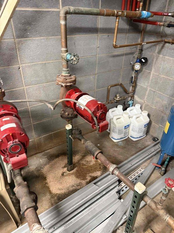Performed commercial tune-up service on two church boilers. Inspected blue cylindrical pressure vessel with copper pipe connections and examined red pump assemblies mounted to copper piping network. System shows normal wear consistent with age. Completed routine maintenance to ensure proper operation for the heating season.