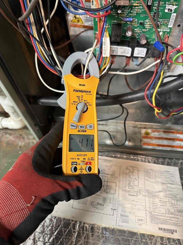 Diagnosed blower motor bearing failure causing loud noise in furnace. Performed electrical testing with clamp meter (reading 411) on control board and inspected motor assembly, which showed signs of wear with dust accumulation. Customer advised of necessary motor replacement.