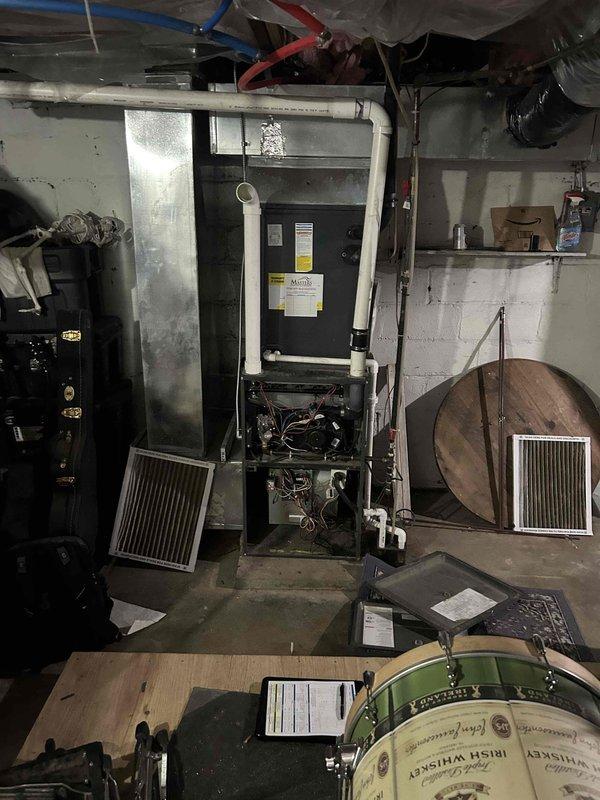 Completed estimate for replacement of gas furnace with damaged heat exchanger and installation of new tankless water heater to replace current leaking unit. Prior repair credit will be applied to this replacement service. Photos documented existing HVAC equipment and water heater in basement mechanical room.