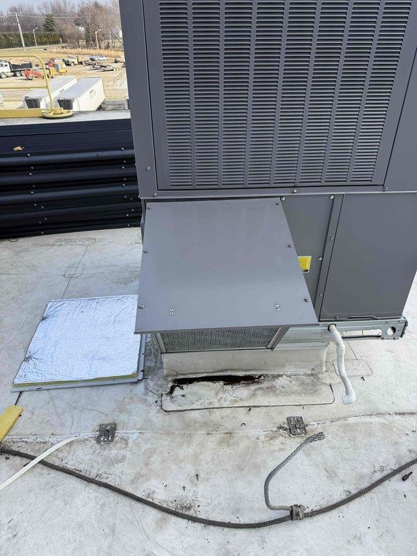 Installed economizer components on rooftop commercial HVAC unit at Americold Logistics facility. System was properly mounted on concrete pad with necessary drainage connections. Confirmed ventilation grilles, access panels and filtration components were in place and functioning as designed.
