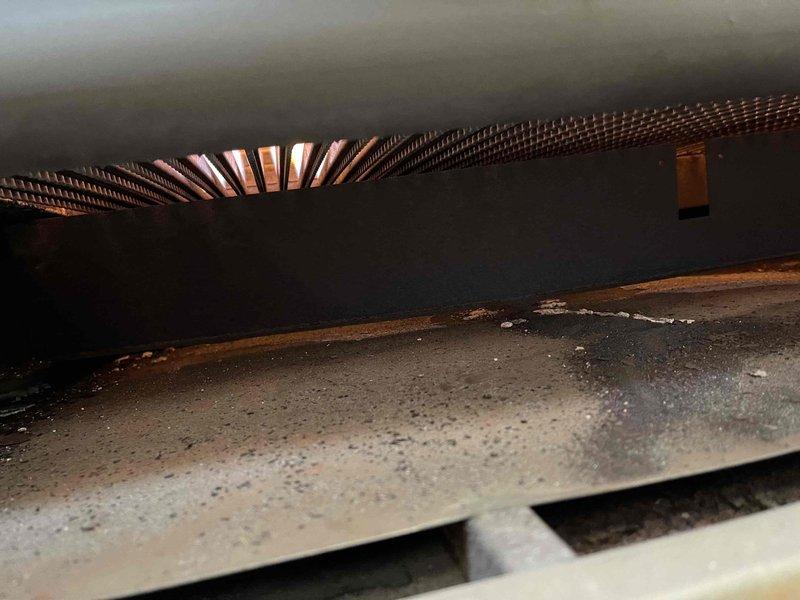 Performed inspection of commercial boiler system at Clayton's Country Bar. Accessed interior components to examine copper heat exchanger coils and identified accumulated dust and debris on metal surfaces. Visual assessment showed no significant damage to coils or interior components.