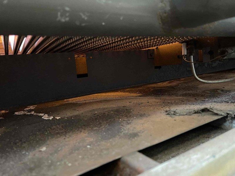 Performed inspection of commercial boiler system at Clayton's Country Bar. Accessed interior components to examine copper heat exchanger coils and identified accumulated dust and debris on metal surfaces. Visual assessment showed no significant damage to coils or interior components.