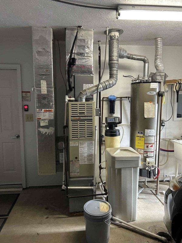 Conducted assessment of existing HVAC system including an aging furnace unit with connected ductwork and a digital Central Temp thermostat (currently reading 65°F). Provided comprehensive replacement estimate for furnace upgrade, considering integration with current water heater, water treatment system, and existing ductwork configuration in the utility room.