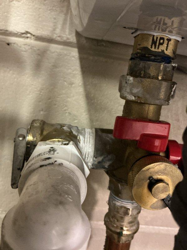 Addressed water heater plumbing leak by replacing deteriorated brass pipe fitting and valve assembly. Installed new NPT-compatible components, including shut-off valve with red handle, and ensured proper connection between copper and PVC sections. System tested and confirmed watertight after repair.
