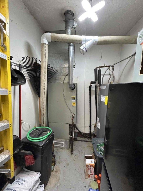 Performed turnover furnace estimate for a residential property with an existing Carrier air conditioning system showing signs of weathering. Inspected the mechanical room which contains the HVAC equipment, water heater, and associated plumbing infrastructure with PVC piping. Documented current system condition for replacement proposal.