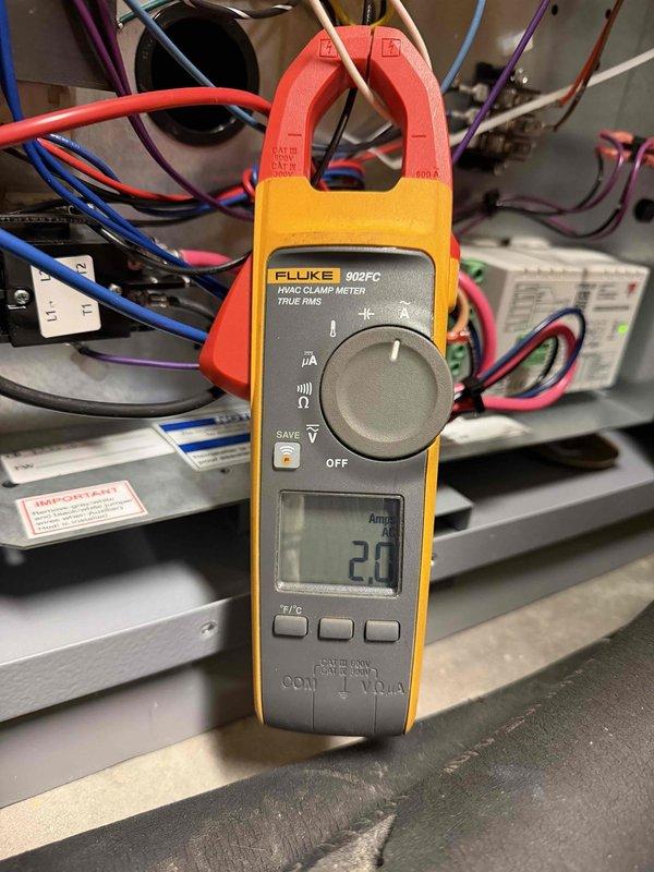 Responded to service call for WaterFurnace system displaying E5 predetect Fp1 error code, which was a recurring issue from two weeks prior. Performed electrical diagnostics using Fluke 902FC clamp meter, measuring amperage and inspecting internal wiring connections. Accessed and examined system components through the bottom panel, focusing on electrical circuits and control board functionality.