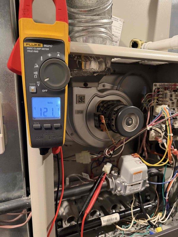 Responded to service call for furnace failure after previous flame sensor replacement in November. Performed electrical diagnostics with Fluke 902FC meter, confirming proper voltage supply at 121V. Inspected blower motor assembly and control board components. Identified and cleaned accumulated debris on replacement flame sensor that was causing intermittent operation failure. System tested and restored to normal operation.