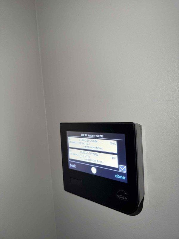 Responded to service call for recurring furnace fault code. Inspected Carrier thermostat system log showing multiple fault events from January. Examined exterior wall vent installation and found improper seating with visible gaps allowing air leakage. Customer currently has heat despite error codes.