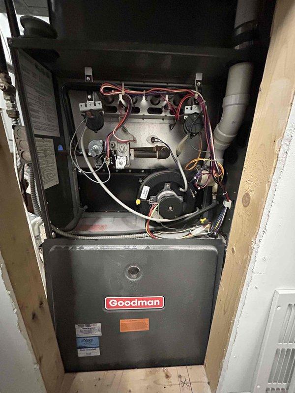 Conducted home estimate for HVAC system replacement. Current installation includes an aging Goodman furnace with visible wiring and components accessible via opened access panel, along with an outdoor condenser unit showing signs of winter exposure and possible ice buildup at base. Customer initiated contact through home show event.
