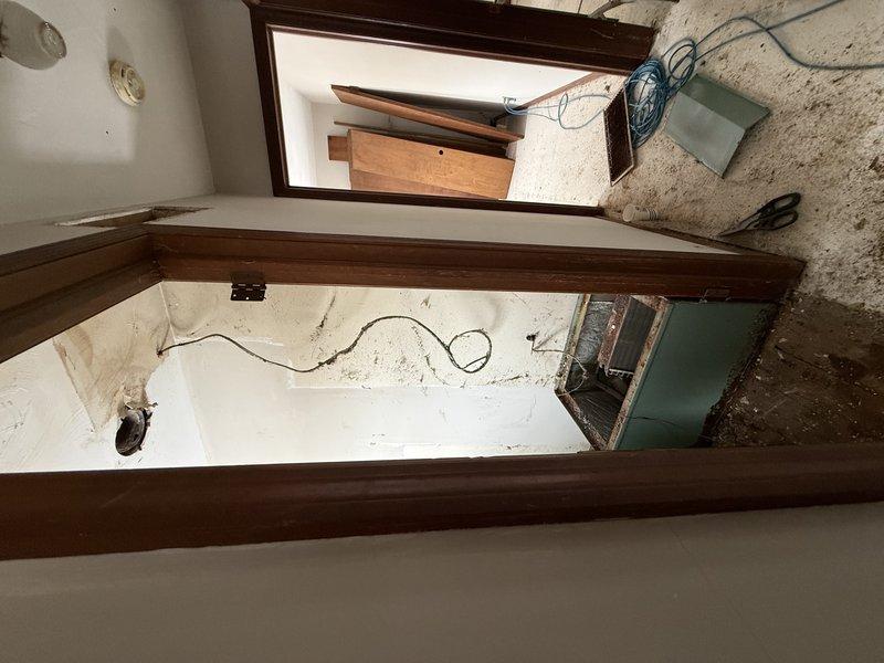 Conducted comprehensive system replacement estimate for a double unit. Visual inspection revealed significant infrastructure issues including exposed electrical wiring throughout the property and extensive rust damage on HVAC components. Property appears to be under renovation with unfinished surfaces and construction debris present.