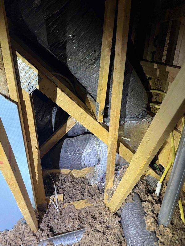 Conducted inspection of attic space to assess airflow distribution issue between main living area and loft. Identified single branch duct from air handler servicing loft area while remaining ducts service opposite side of home. Documented current duct configuration and insulation condition with photos for potential zoning system installation. Measurements taken for comprehensive quote to improve thermal comfort in upstairs/loft area.