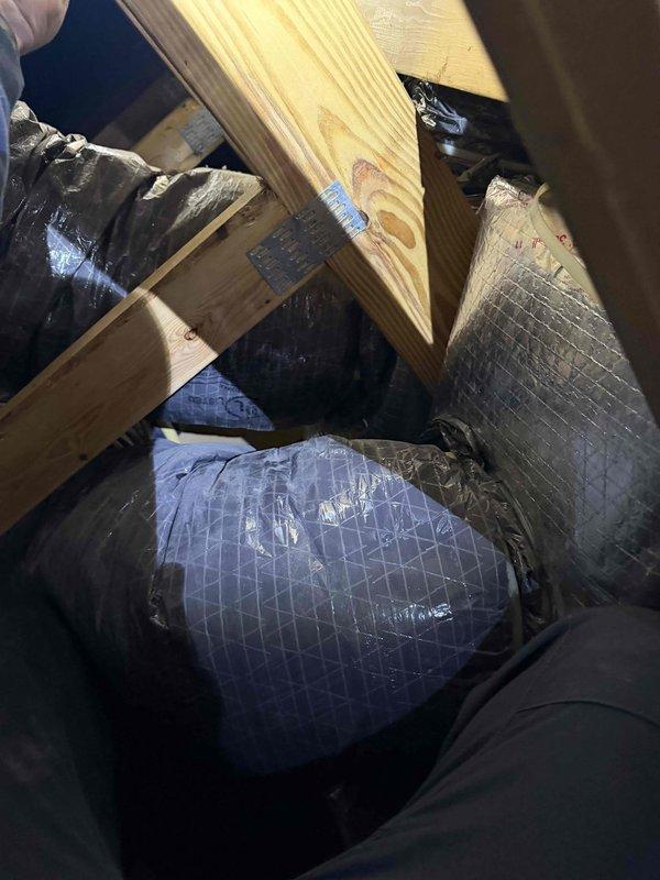 Conducted inspection of attic space to assess airflow distribution issue between main living area and loft. Identified single branch duct from air handler servicing loft area while remaining ducts service opposite side of home. Documented current duct configuration and insulation condition with photos for potential zoning system installation. Measurements taken for comprehensive quote to improve thermal comfort in upstairs/loft area.